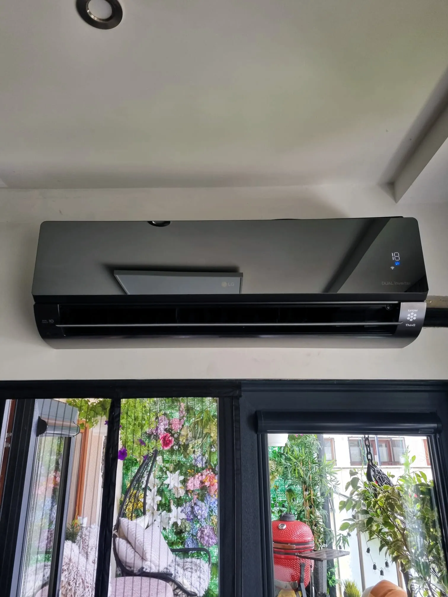 Black wall-mounted air conditioner above a patio door