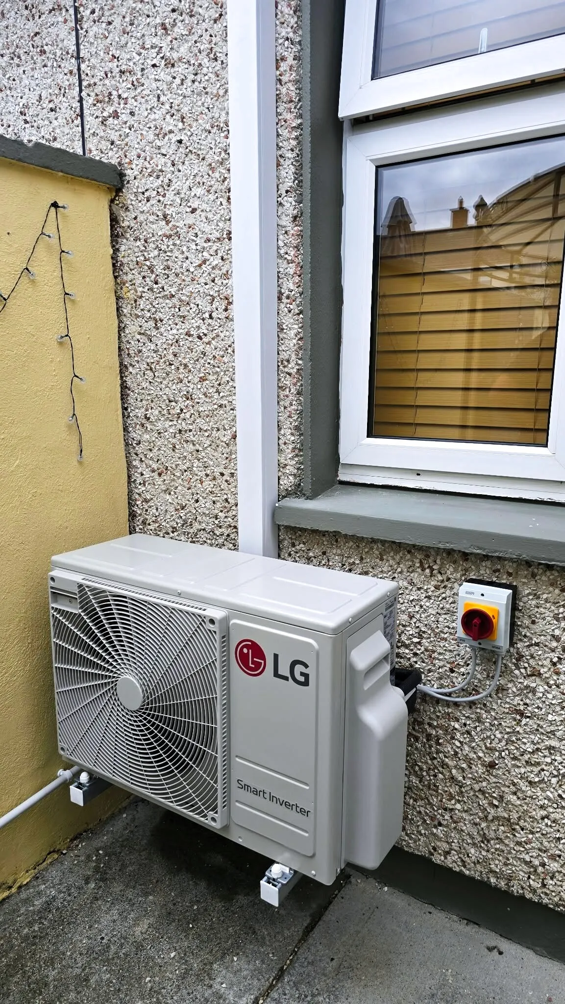 LG outdoor unit installed under a window