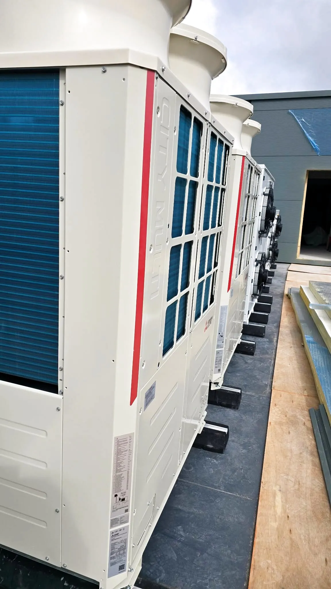 Row of Mitsubishi VRF outdoor units, side view
