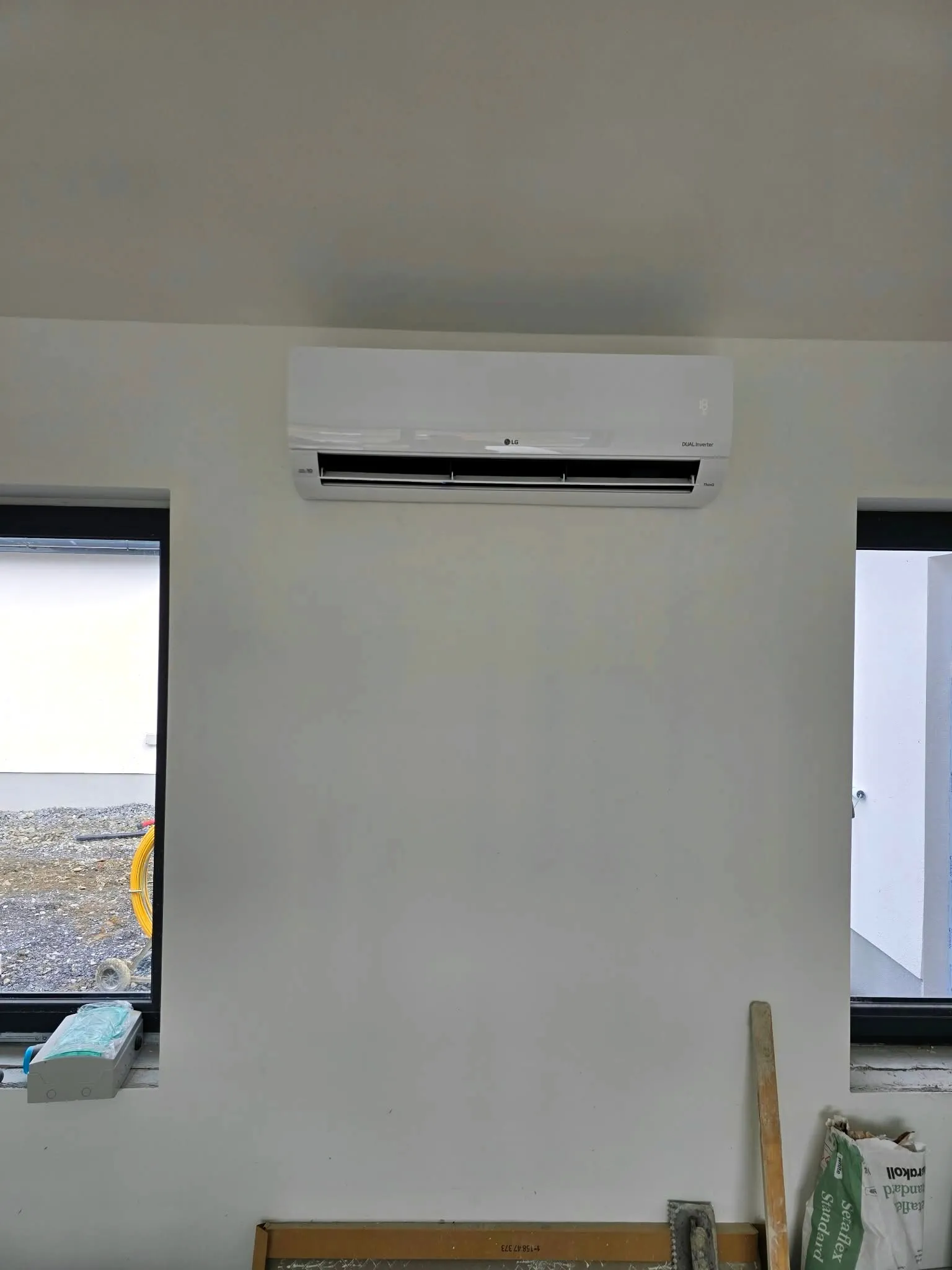 Wall-mounted air conditioner between two windows
